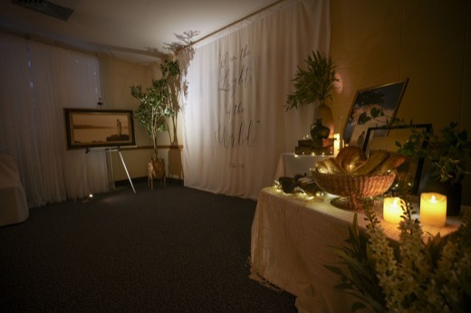 A banner reading I am the Light of the World, beside a basket of bread and candles.